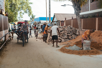 Image showing Malagasy men working hard, manually carrying construction stones. Morondava, Madagascar