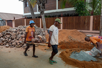 Image showing Malagasy men working hard, manually carrying construction stones. Morondava, Madagascar