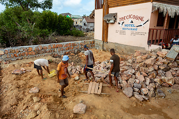 Image showing Malagasy men working hard, manually carrying construction stones. Morondava, Madagascar