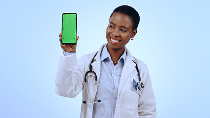 Image showing Green screen, black woman and doctor with a smartphone, smile and healthcare on blue background. African person, medical or professional with a cellphone, tracking markers and promotion with medicare