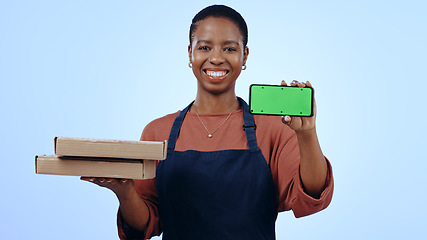 Image showing Black woman, food delivery and smartphone with smile, portrait and chromakey on blue studio background. Waitress, technology and online for order, communication and worker for pizza, apron or service