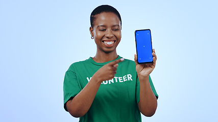 Image showing Woman, volunteer and phone green screen, presentation mockup and support, join us or marketing in studio. Happy African person pointing to mobile, information and NGO volunteering on blue background