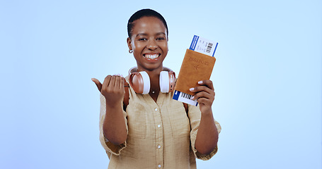 Image showing Happy woman, smile and ticket for flight in studio with mock up for travel on blue background with passport. Portrait, black person and excited with hand for invite with deal, discount and vacation