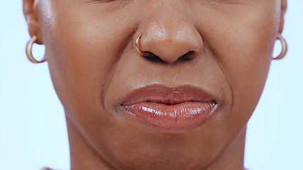 Image showing Woman, face and closeup of nose and mouth in studio with disgust for bad smell, dislike scent or air. Person, negative facial expression or reaction to sweat, nausea or aroma on blue background