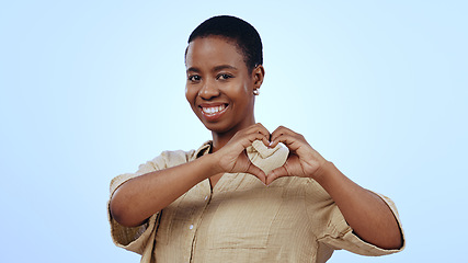 Image showing Heart, hands and portrait of black woman in studio for kindness, care and charity donation on blue background. Happy model show sign of love, hope and thank you for support, emoji and review of peace