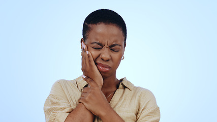 Image showing Woman, hand and toothache pain in studio for gum disease injury or oral gingivitis, blue background as mockup. Black person, face and problem in dental care for frustrated worry, cavity or swollen