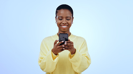 Image showing Happy woman, smile or texting on mobile app in studio for mockup of social media on blue background. Black person, face and looking at screen for email, message or reading on internet, online or web