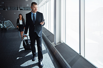 Image showing Business man, woman and smartphone in airport hallway with smile, thinking or suitcase for international travel. Entrepreneur, luggage and phone with flight schedule for global immigration in London