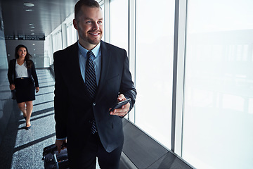 Image showing Business man, woman and phone by airport window for vision, thinking and contact in corridor with smile. Entrepreneur, suitcase and smartphone with flight schedule for global immigration in London