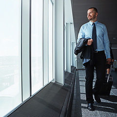 Image showing Walking, thinking or happy businessman in airport for a company trip with suitcase or luggage for commute. Smile, window or corporate workers in lobby for travel or journey on international flight