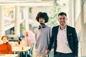 Image showing In a modern startup office setting, a business director and a young African American entrepreneur sit surrounded by their colleagues, embodying diversity and teamwork in the corporate world.