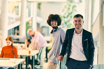 Image showing In a modern startup office setting, a business director and a young African American entrepreneur sit surrounded by their colleagues, embodying diversity and teamwork in the corporate world.