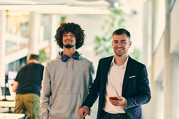 Image showing In a modern startup office setting, a business director and a young African American entrepreneur sit surrounded by their colleagues, embodying diversity and teamwork in the corporate world.