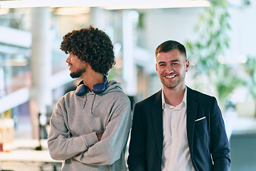 Image showing In a modern startup office setting, a business director and a young African American entrepreneur sit surrounded by their colleagues, embodying diversity and teamwork in the corporate world.