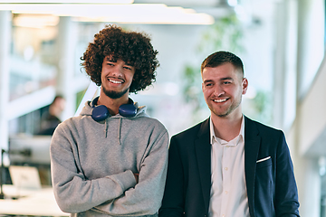 Image showing In a modern startup office setting, a business director and a young African American entrepreneur sit surrounded by their colleagues, embodying diversity and teamwork in the corporate world.