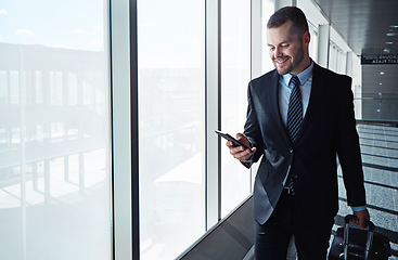 Image showing Business man, cellphone and window in airport hallway for reading, thinking or vision on international travel. Entrepreneur, luggage and smartphone for flight schedule or global immigration in London