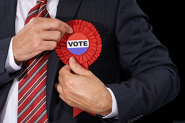 Image showing Man, vote and suit for election, ribbon and politician for support and on dark studio background. Politics, voter choice and representative for party, registration and democracy for voting register