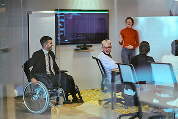 Image showing A pregnant business woman with orange hair confidently presents her business plan to colleagues in a modern glass office, embodying entrepreneurship and innovation