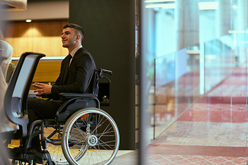 Image showing In a modern glass startup office, a wheelchair-bound director leads a successful meeting with colleagues, embodying inclusivity and teamwork.