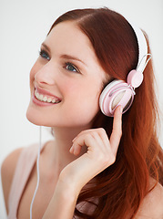 Image showing Smile, headphones and young woman in a studio listening to music, playlist or album. Happy, excited and female model from Canada streaming a song, podcast or radio isolated by white background.