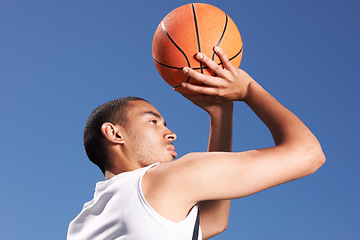 Image showing Basketball, player and game shoot in blue sky on outdoor court as fitness challenge or sports train, match as athlete. Man, score and summer goal dunk or competition winner, strong skill or confident