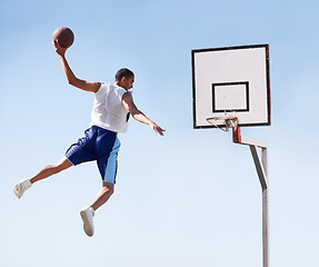 Image showing Man, basketball and dunk jump on outdoor court for scoring point, game challenge or athlete. Male person, hand and hoop strong for exercise fun or fitness training in summer, player for winner match