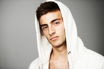 Image showing Confident, portrait and man in hoodie for fashion isolated on a gray background. Serious young person, face of model and streetwear clothes, casual and cool facial expression in Spain on mockup space