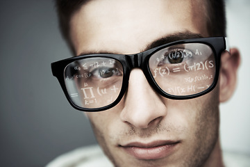 Image showing Portrait, glasses and formula with a man programmer closeup in studio on a gray background for support. Face, eyewear and software development with a young nerd or geek reading coding data or info