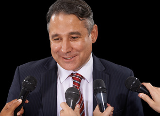 Image showing Microphone, business and man with press conference, smile and information on a dark studio background. Government official, person or interview with questions, statement and speaking with news or mic