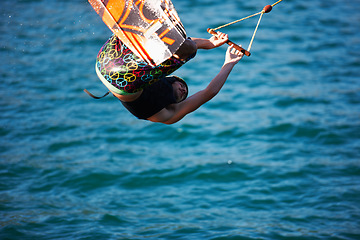 Image showing Man, wakeboarding and ocean with jump, sport and fitness with speed on vacation in summer sunshine. Person, athlete and ski with rope for safety on lake, sea or river with training, exercise or waves