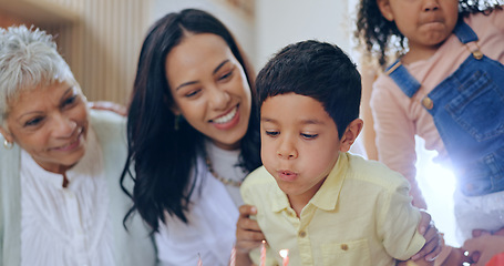 Image showing Birthday cake, child blowing candles and big family to celebrate with smile, fun and love together in home. Happiness, boy and congratulations, mom and grandparents at kids party with excited people.