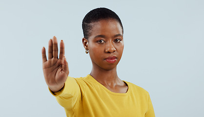 Image showing Black woman, portrait and hand in stop for protest, rejection or no isolated against a gray studio background. Face of serious African female person or model with gesture for halt or refuse on mockup