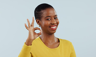 Image showing Happy black woman, portrait and OK sign for success or approval against a gray studio background. Face of African female person or model smile with like emoji, yes or okay for perfect or good job