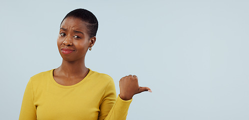 Image showing Disappointed, pointing and portrait of black woman in studio with why, question and doubt. Emoji, what and face of person with hand gesture for announcement, information and news on blue background