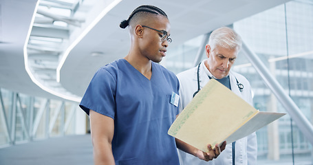 Image showing Nurse, healthcare report and doctor for reading in hospital corridor, confused and medical results. Specialist, feedback and young medic with patient information, question and diversity in teamwork