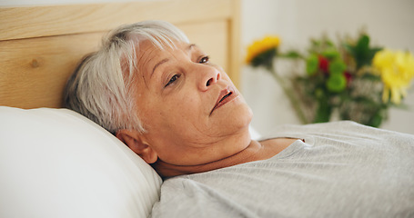 Image showing Depression, tired and an elderly woman in bed for peaceful rest or to relax in her retirement home closeup. Face, morning or insomnia with a senior person exhausted in the bedroom of an apartment