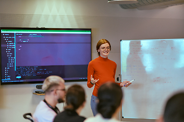 Image showing A pregnant business woman with orange hair confidently presents her business plan to colleagues in a modern glass office, embodying entrepreneurship and innovation