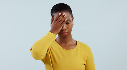 Image showing Frustrated black woman, headache and stress in mistake, fail or loss against a gray studio background. Face of tired African female person or model with migraine in disappointment, burnout or fatigue