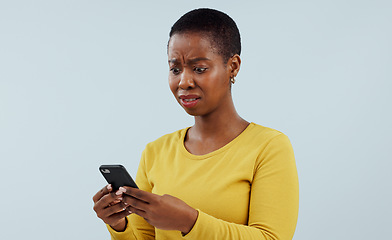 Image showing Frustrated black woman, phone and shocking news on social media, terrifying or bad against a studio background. Disturbed face of African female person on mobile smartphone for alert or notification