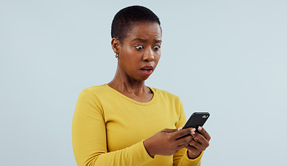 Image showing Black woman, phone and shocking news on social media, terrifying or online against a studio background. Face of surprised African female person or model on mobile smartphone for alert notification