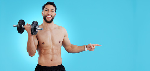 Image showing Gym, portrait and happy man with dumbbell or hand pointing to studio for fitness, promo or info on blue background. Face, smile and male bodybuilder show sign up, presentation or membership offer