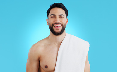 Image showing Shower, portrait and happy man in studio with towel for body care, wellness or grooming on blue background. Face, smile and model smile for beauty results, treatment or glow from bathroom routine