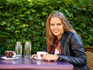 Image showing Portrait, smile and woman at coffee shop outdoor, garden and restaurant table. Face, happy person and girl at cafe with tea cup, espresso and customer drink latte to relax at cafeteria in Switzerland