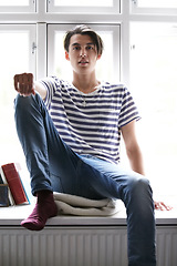 Image showing Portrait, window and an asian man in the bedroom of his home to relax in the morning of a weekend in summer. Fashion, style and a confident young model chilling in his apartment for time off