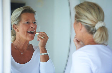 Image showing Senior woman, lipstick and mirror in home with smile, thinking and beauty to start morning in retirement. Elderly person, makeup and product for lips, reflection and happy in bathroom for cosmetics