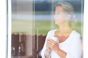 Image showing Senior, woman and coffee at window thinking for morning plans in retirement, vacation or relax rest. Female person, latte drink and thoughts at view in home for holiday decision, calm peace in lounge