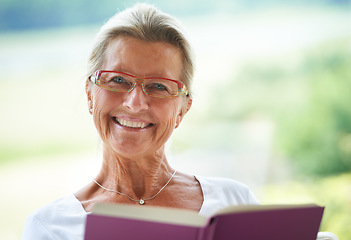Image showing Senior woman, home and book in portrait for reading, relax and living room with smile for story, knowledge or glasses. Happy elderly lady, person and face in lounge in retirement with novel in house