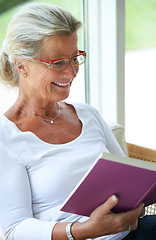 Image showing Senior woman, home and book with smile for reading, relax and living room with ideas for story, knowledge or glasses. Happy elderly lady, person and vision in lounge in retirement with novel in house