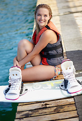 Image showing Woman, happy or wakeboard by water, lake or ocean sea with ideas, vision or planning fitness hobby. Person, life jacket or athlete smile with swimsuit, exercise and sports training equipment on break