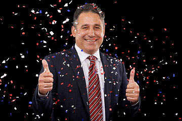 Image showing Business man, thumbs up and confetti for celebration, success and winning, thank you or support in election in studio. Portrait of professional winner in suit, like emoji and vote on black background